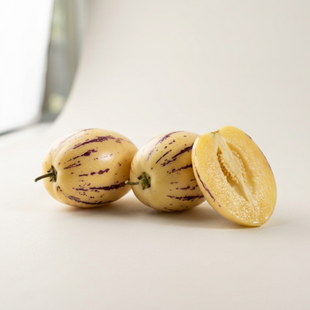 Immagine illustrativa di pepino intero e tagliato su sfondo chiaro
